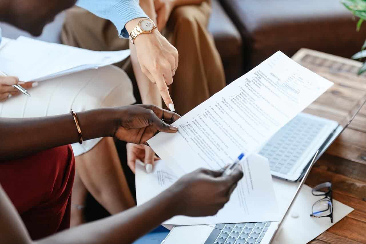 Persona revisando en su mesa los recibos de varios préstamos activos para calcular cuántos puede tener a la vez