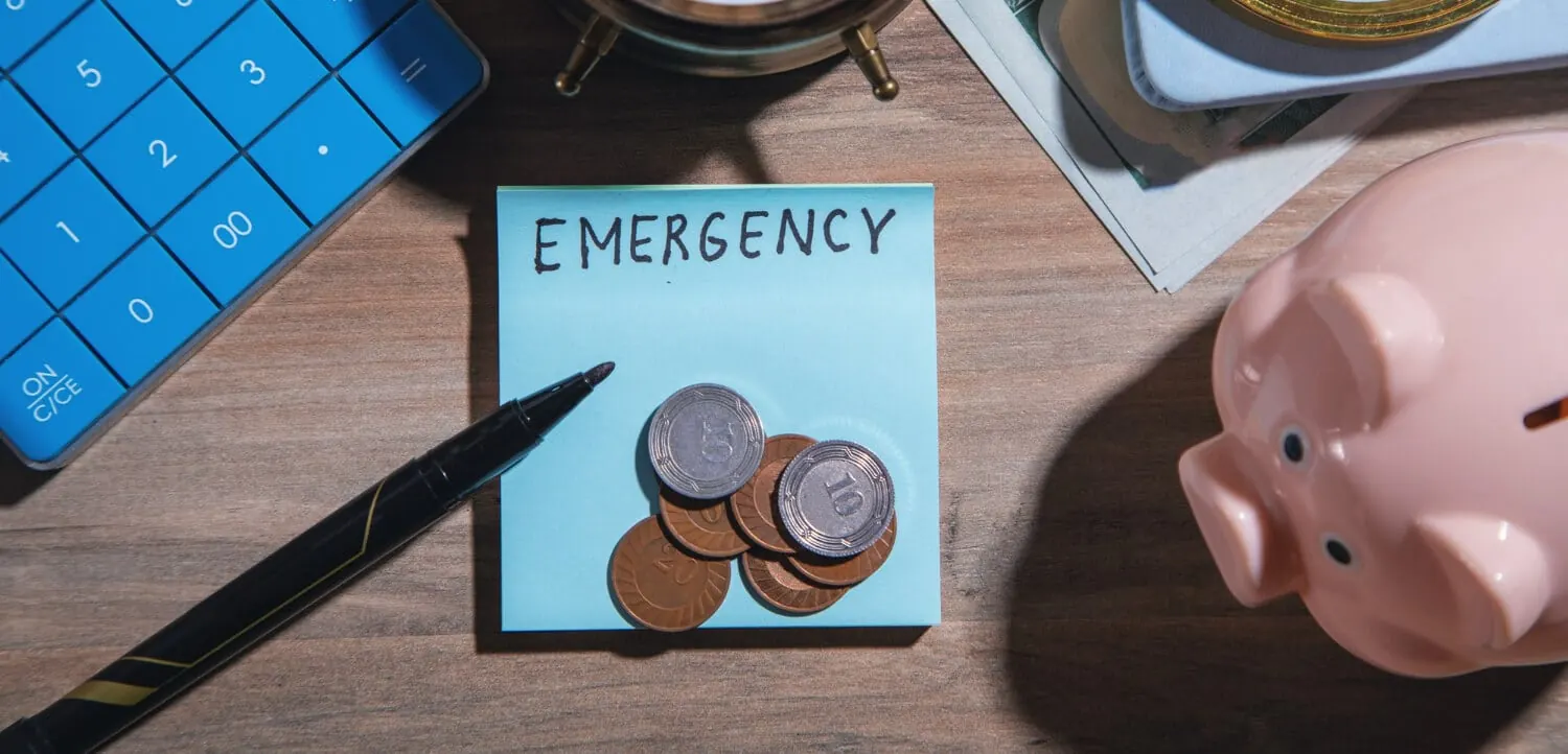 Persona calculando con una calculadora y documentos cuánto puede pedir en un préstamo de emergencia para un gasto imprevisto
