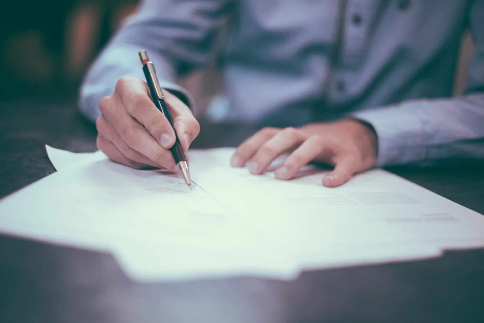 Persona revisando la documentación de un préstamo puente para comprar una vivienda antes de vender la actual